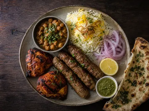Representative Pakistani seekh kabob with chicken tikka, basmati rice, chana, mint chutney, onions, and naan selected for Ravi Kabob House